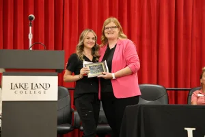 A medical assistant graduate receiving an award during the program's annual pinning ceremony.