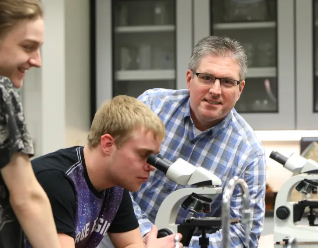 Photo of Jeff White helping a biology student