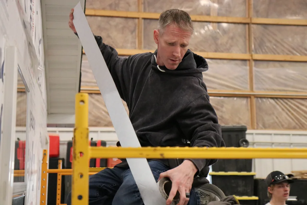 A photograph of a student working in construction.