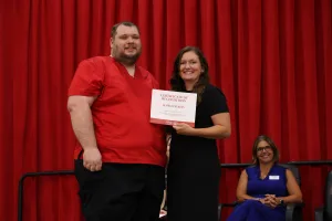 A nursing graduate receiving an award at the Practical Nursing pinning ceremony.