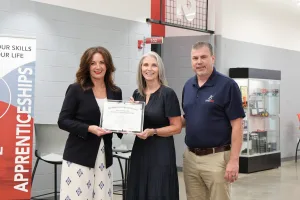 Two workforce experts presenting a certificate to an individual who recently completed a registered apprenticeship.